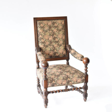 Large wooden arm chair with floral design and balls on arms
