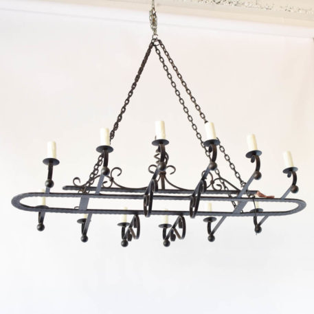 Very large vintage Spanish iron chandelier with central oval frame with hammered design and open basket in the middle