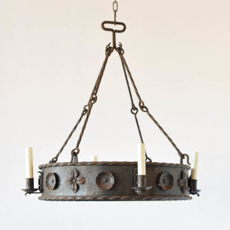 Vintage French chandelier made of a simple iron band adorned with 2 types of stamped metal flowers. The fixture is suspended from four sets of rods with twisted iron in the center and loops on the ends