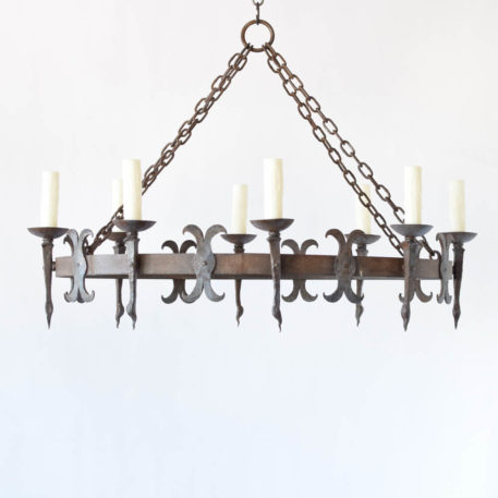 Large Oval shaped chandelier from France with hand forged torch style arms and alternating fleur de lis details