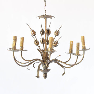 Vintage iron chandelier with an elongated overall shape decorated in the center with poppy flowers and furhter accented by leaves under each arm that has a star shaped bobesche under the candle