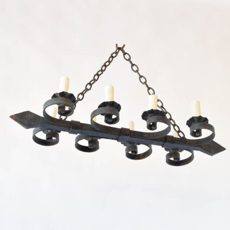 Hand forged French chandelier with thick central rail supporting 8 curls and bobesches