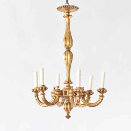 Italian wood chandelier with tall thin carved column supporting 6 fluted wood arms with gilded finish