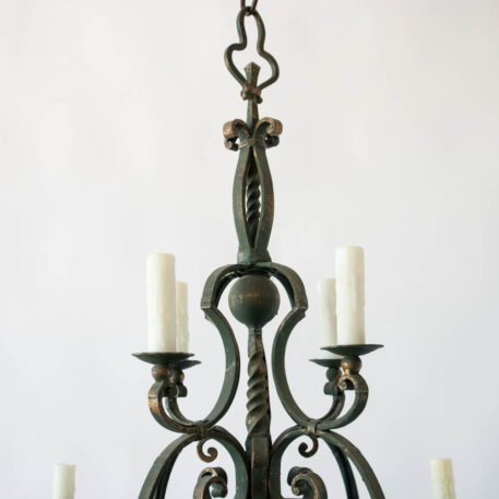Flemish or French style pair of iron chandeliers with scroll arms and green color decorative column and gold details and fleu de lis on arms