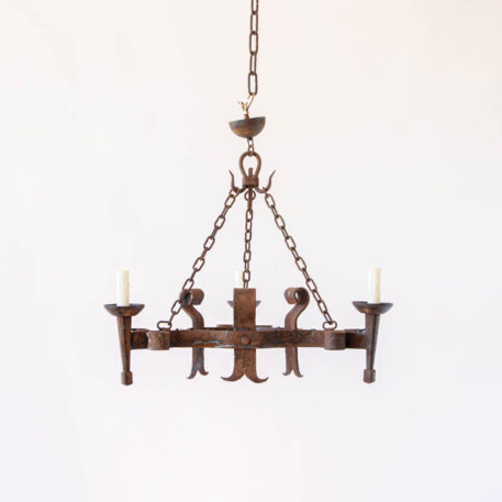 Heavy rusty iron 3 light chandelier with split straps in triangular shape with scrolls and torches and hooks