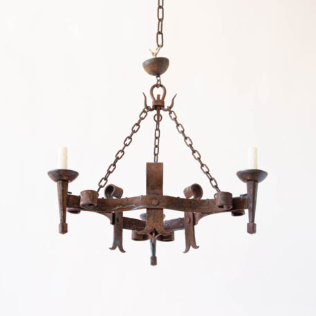 Heavy rusty iron 3 light chandelier with split straps in triangular shape with scrolls and torches and hooks